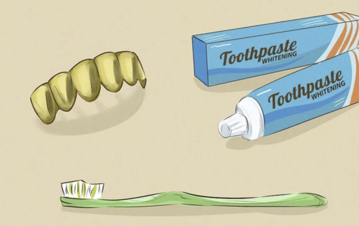 Cleaning a set of gold grillz with a soft-bristled toothbrush